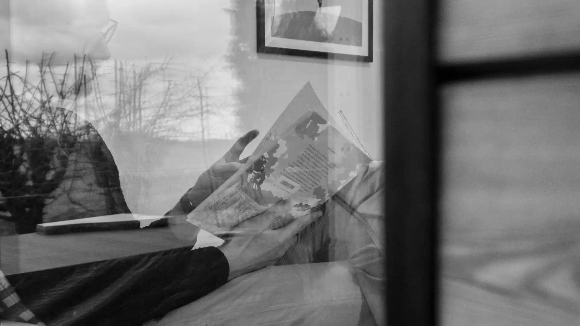 Tiny House La Ruche Brabant Wallon – Personne lisant un livre vu à travers une vitre