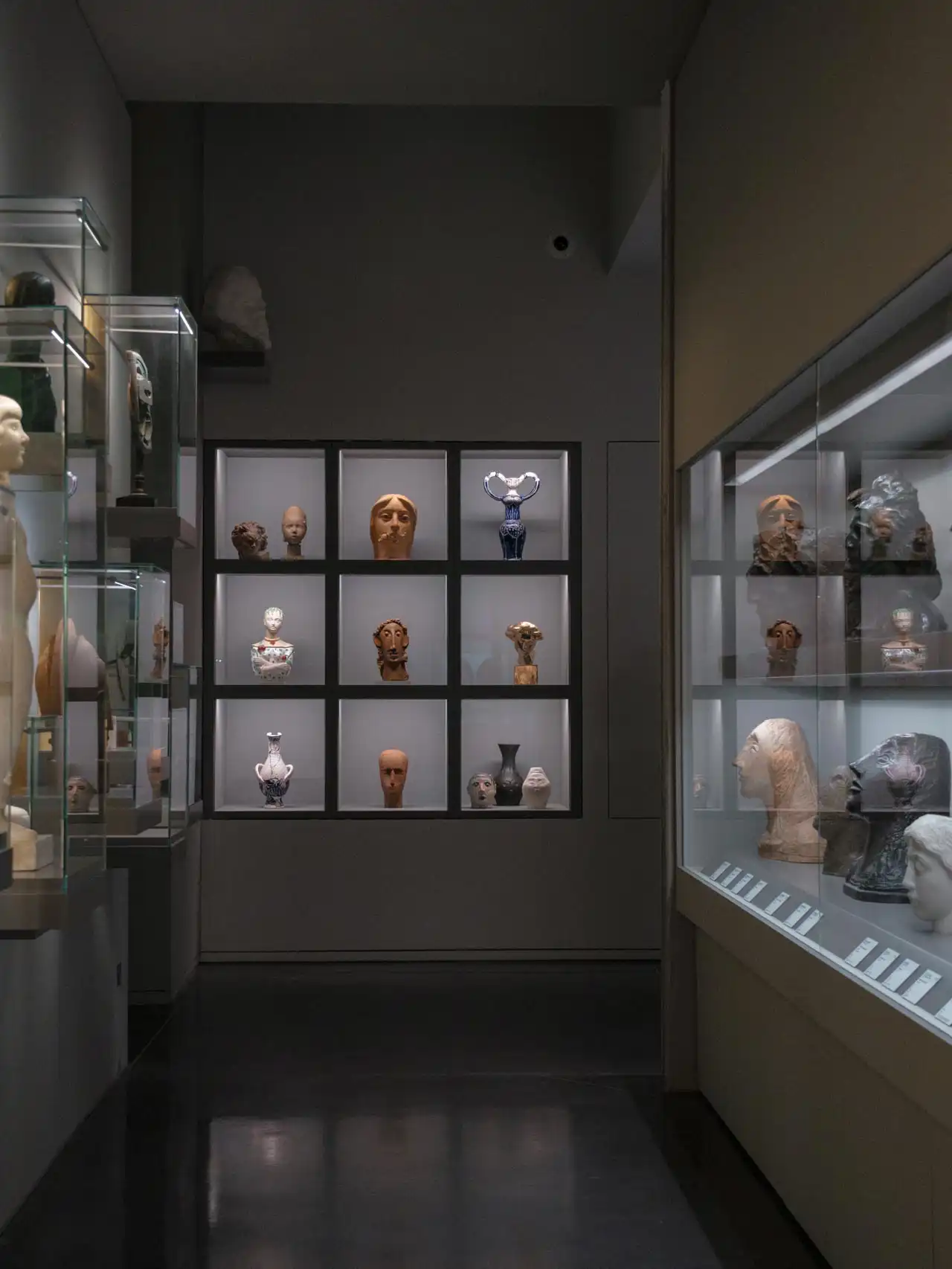 Couloir du musée La Piscine sombre avec sculptures dans le fond