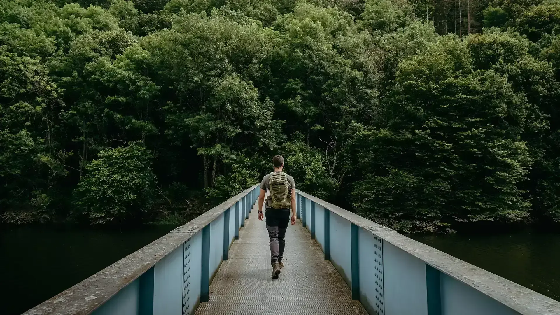 Randonneur sur un pont traversant l'Our, rivière à Bivels au Luxembourg