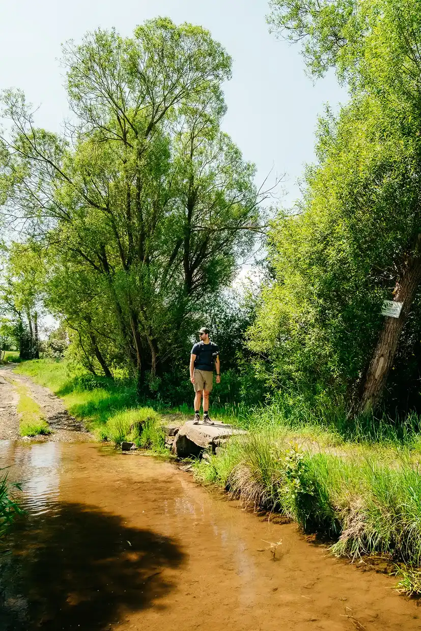 randonneur traversant un pont sur le trek Gouvy-Aywaille en Wallonie